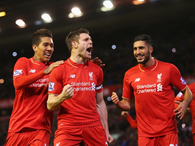 James Milner of Liverpool (C) celebrates with Roberto Firmino (L) and Emre Can (R) as he scores their first goal from a penalty during the Barclays Premier League match between Liverpool and Swansea City at Anfield on November 29, 2015