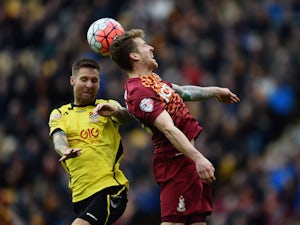 Billy Clarke of Bradford City rises for the ball with Bruce Wilson of Chesham United during The Emirates FA Cup Second Round match between Bradford City and Chesham United at Coral Windows Stadium, Valley Parade on December 6, 2015 in Bradford, England.