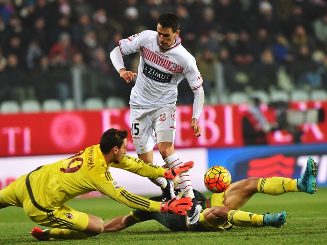 AC Milan's goalkeeper from Italy Gianluigi Donnarumma (L) saves a shot by Carpi's forward from Italy Kevin Lasagna (C) and AC Milan's defender from Brazil Alex (R) during the Italian Serie A football match Carpi vs AC Milan at the Braglia stadium in Moden