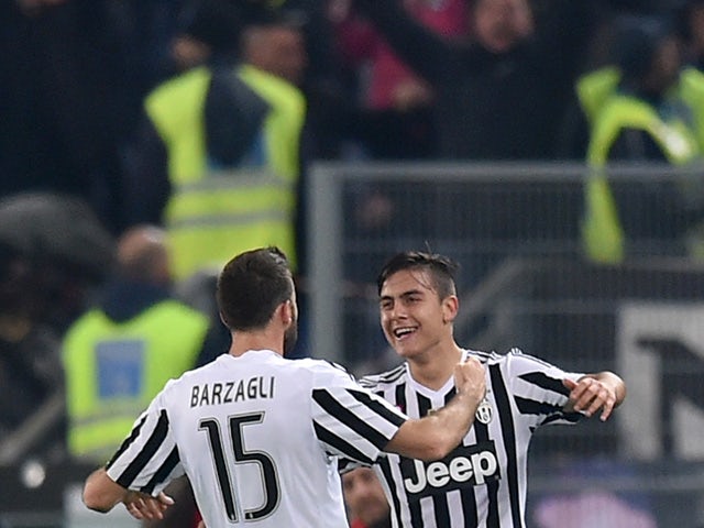 Juventus' forward from Argentina Paulo Dybala (R) celebrates after scoring with Juventus' defender from Italy Andrea Barzagli during the Italian Serie A football match SS Lazio versus Juventus on December 4, 2015