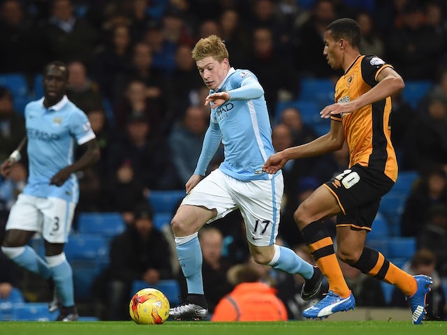 Manchester City's Belgian midfielder Kevin De Bruyne (C) runs with the ball tracked by Hull City's English defender Isaac Hayden (R) during the English League Cup quarter-final football match between Manchester City and Hull City at the Etihad Stadium in 