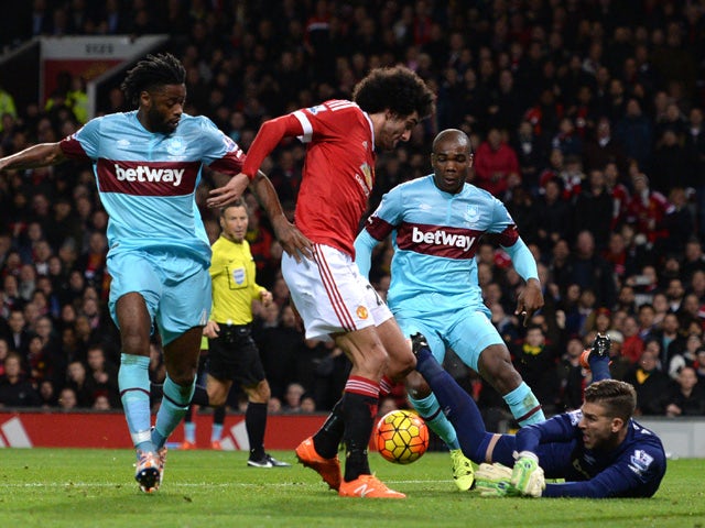 West Ham United's Spanish goalkeeper Adrian (R) saves a shot by Manchester United's Belgian midfielder Marouane Fellaini during the English Premier League football match between Manchester United and West Ham United at Old Trafford in Manchester, north we