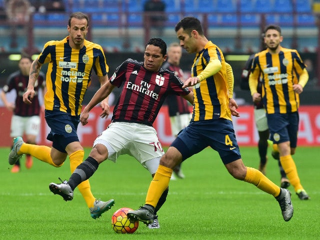 AC Milan's forward from Colombia Carlos Bacca (L) fights for the ball with Hellas Verona's defender from Mexico Rafael Marquez during the Italian Seria A football match AC Milan vs Hellas Verona at San Siro Stadium in Milan on December 13, 2015