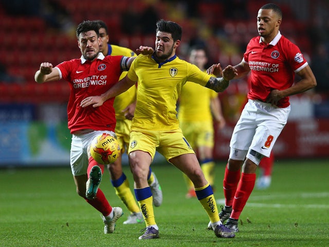Alex Mowatt of Leeds (C) competes for the ball with Johnnie Jackson of Charlton (L) during the Sky Bet Championship match between Charlton Athletic and Leeds United at The Valley on December 12, 2015