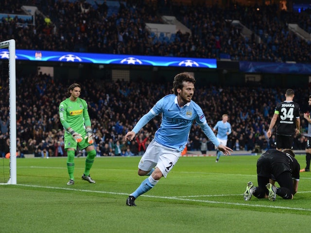 Manchester City's Spanish midfielder David Silva (C) wheels away to celebrate scoring the opening goal during the UEFA Champions League Group D football match between Manchester City and Borussia Moenchengladbach at the Etihad Stadium in Manchester, north