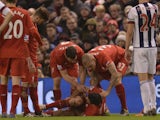 Liverpool's English midfielder James Milner (L) and Liverpool's Slovakian defender Martin Skrtel (R) aid Liverpool's Croatian defender Dejan Lovren (C) who was injured in a challenge with West Bromwich Albion's English midfielder Craig Gardner during the 
