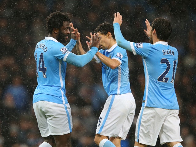 Wilfred Bony (L) of Manchester City celebrates scoring his team's first goal with his team mates Jesus Navas (C) and David Silva (R) during the Barclays Premier League match between Manchester City and Swansea City at Etihad Stadium on December 12, 2015