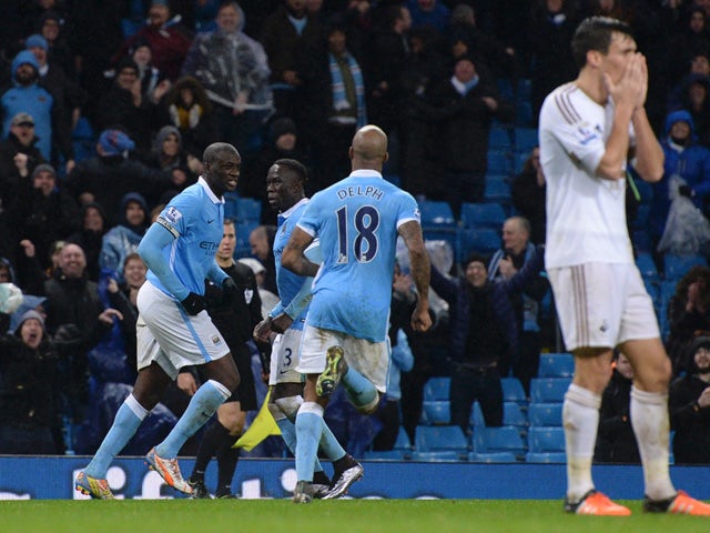 Manchester City's Ivorian midfielder and captain Yaya Toure (L) celebrates his late winning goal during the English Premier League football match between Manchester City and Swansea City at the Etihad Stadium in Manchester, north west England, on December