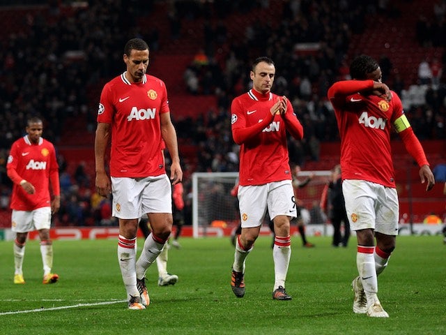 Dejected Manchester United players leave the field after losing to Benfica in the Champions League on November 22, 2011