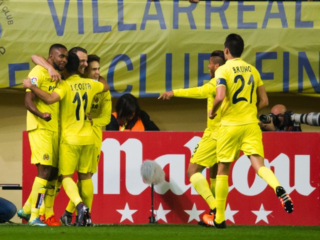 Players of Villarreal CF celebrate after their teammate Roberto Soldado scored the opening goal during the La Liga match between Villarreal CF and Real Madrid CF at El Madrigal on December 13, 2015