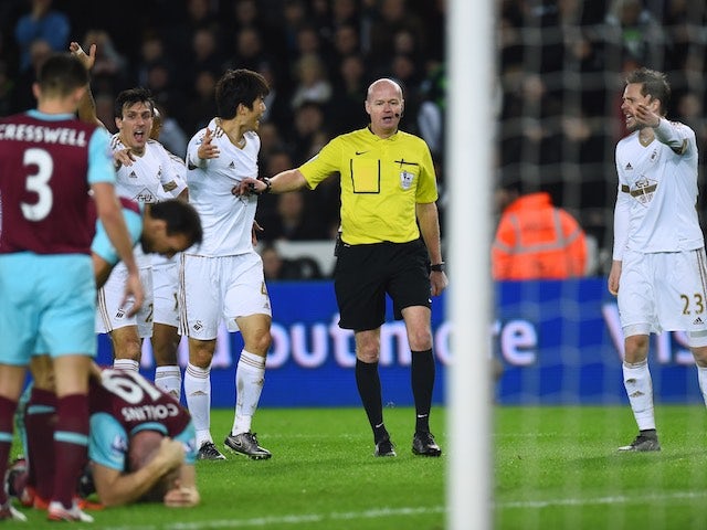 Swansea players appeal to referee Lee Mason after West Ham's James Collins appeared to handle the ball on December 20, 2015