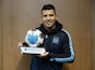 Sergio Aguero poses up against a cupboard with his player of the month award for January 2016