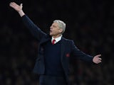 Arsene Wenger practises semaphore during the Champions League game between Arsenal and Barcelona on February 22, 2016