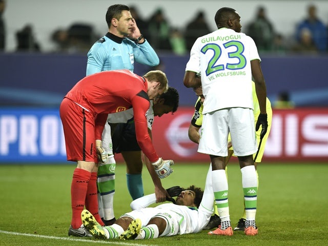 Wolfsburg's Dante gets help after clashing with Gent's goalkeeper Matz Sels at the Volkswagen arena in Wolfsburg on March 8, 2016