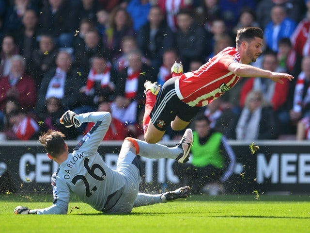 Karl Darlow tackles Shane Long during the Premier League match between Southampton and Newcastle United on April 9, 2016