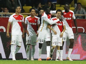 Monaco strike late to move top