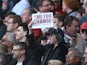 A fan holds up an itimidating piece of A4 paper in protest at Arsene Wenger during the Premier League game between Arsenal and Norwich City on April 30, 2016