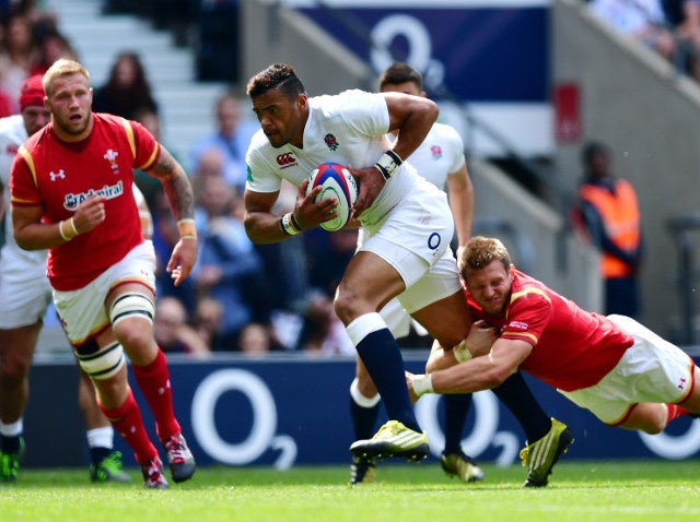 England centre Luther Burrell powers through the tackle of Wales fly-half Dan Biggar en route to scoring the opening try of their match against Wales at Twickenham on May 29, 2016