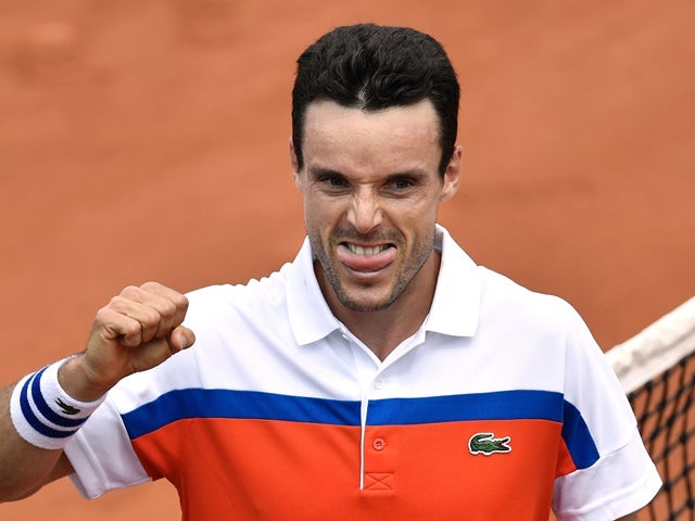 Roberto Bautista-Agut eats a sausage after winning his men's second-round match against Paul-Henri Mathieu at the French Open on May 26, 2016