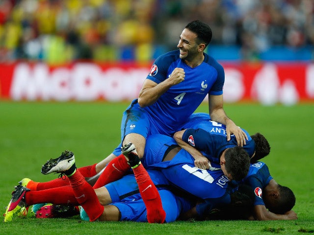 Adil Rami (top) and French players celebrate their team's second goal scored by Dimitri Payet (obscured) during the UEFA Euro 2016 Group A match between France and Romania at Stade de France on June 10, 2016 in Paris, France
