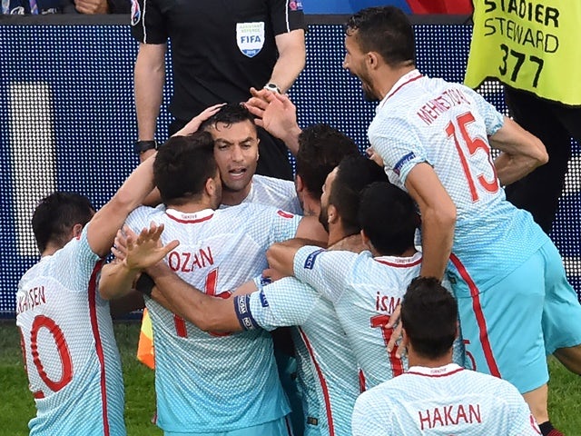 Burak Yilmaz is congratulated by teammates after scoring a goal during the Euro 2016 group D football match between Czech Republic and Turkey on June 21, 2016