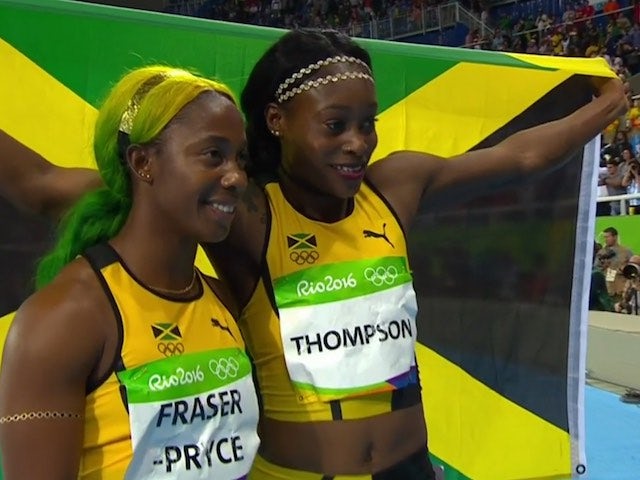Shelly-Ann Fraser-Pryce and Elaine Thompson pose with the Jamaican flag after the women's 100m final on August 13, 2016