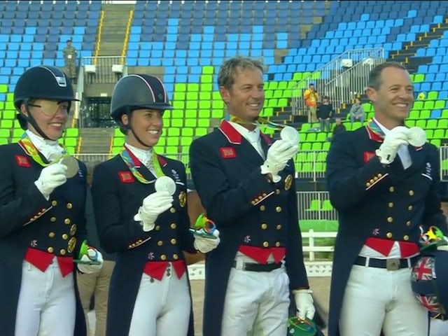 Watched on by their respective horses, Team GB's dressage team celebrate winning silver at the Rio Olympics on August 12, 2016