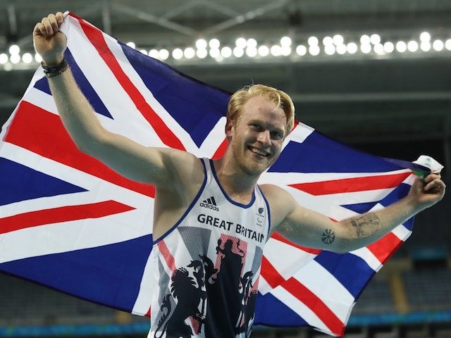 Jonnie Peacock poses with the GB flag after winning gold in the men's T44 100m final at the Rio Paralympics on September 9, 2016