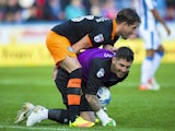 Sheffield Wednesday goalkeeper Keiren Westwood and teammate Sam Hutchinson forget themselves during the Championship match against Huddersfield Town on October 16, 2016