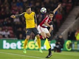 Fabio and Mesut Ozil in action during the Premier League game between Middlesbrough and Arsenal on April 17, 2017