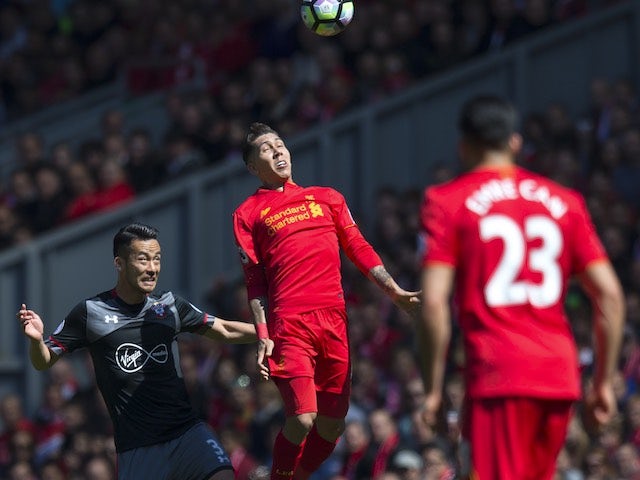 Roberto Firmino tussles with Maya Yoshida as Emre Can watches on during the Premier League game between Liverpool and Southampton on May 7, 2017