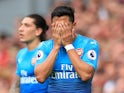 Alexis Sanchez hides his face in shame during the Premier League game between Liverpool and Arsenal on August 27, 2017