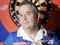 Phil 'The Power' Taylor posing up against a dartboard in late 2009
