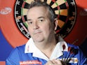 Phil 'The Power' Taylor posing up against a dartboard in late 2009