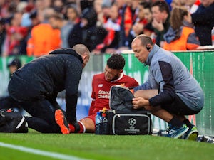 Alex Oxlade-Chamberlain sits injured during the Champions League semi-final game between Liverpool and Roma on April 24, 2018