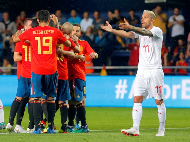 Spain's Alvaro Odriozola celebrates scoring their first goal with teammates as Switzerland's Valon Behrami reacts
