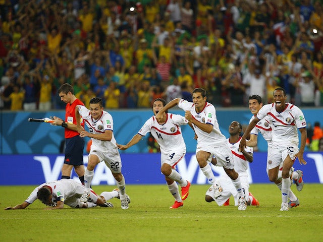 Costa Rica's players celebrate qualifying for the quarter-finals of the 2014 World Cup