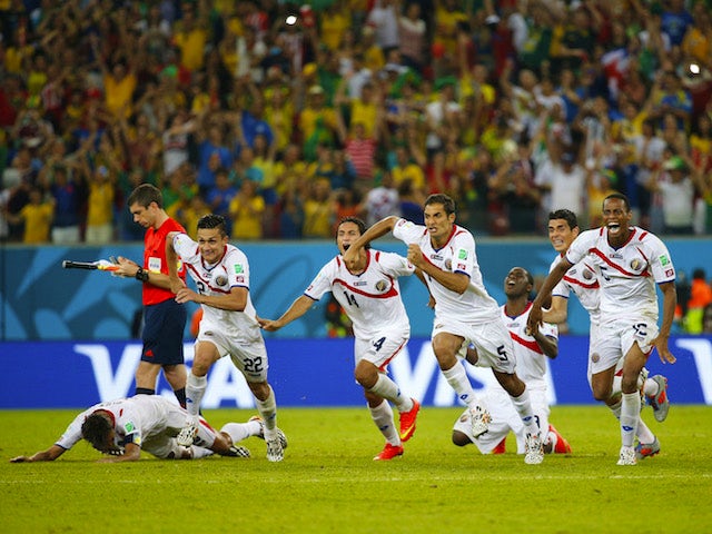 Costa Rica's players celebrate qualifying for the quarter-finals of the 2014 World Cup