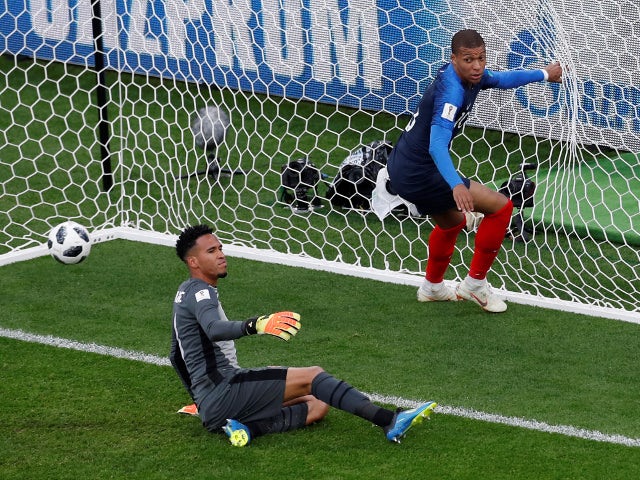 Peru's Pedro Gallese looks dejected as France's Kylian Mbappe celebrates scoring their first goal on June 21, 2018