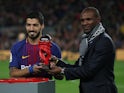 Barcelona's Luis Suarez is presented with the player of the month award for December by Eric Abidal on January 28, 2018 