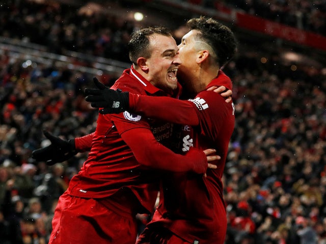 Roberto Firmino embraces Xherdan Shaqiri in celebration during the Premier League game between Liverpool and Manchester United on December 16, 2018