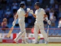 England's Joe Root and Joe Denly celebrate during the third Test against West Indies on February 11, 2019