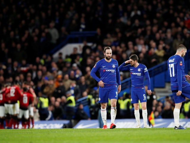 Chelsea's players look dejected as Manchester United celebrate their opening goal on February 18, 2019