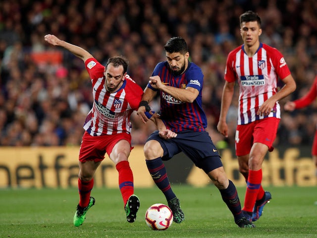 Barcelona's Luis Suarez battles with Atletico Madrid's Diego Godin in their La Liga clash on April 6, 2019