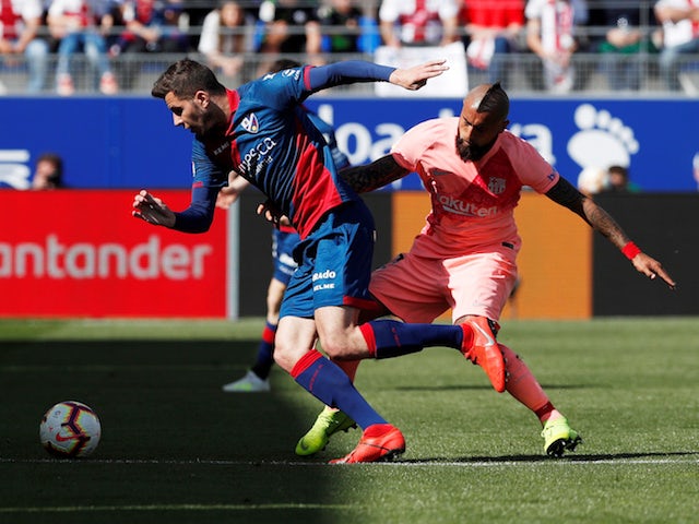 Barcelona's Arturo Vidal battles Huesca's Christian Rivera for the ball in La Liga on April 13, 2019