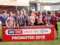 Lincoln City players celebrate winning promotion to League One on April 13, 2019