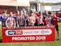 Lincoln City players celebrate winning promotion to League One on April 13, 2019