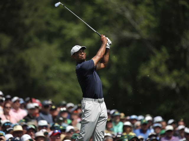 Woods overcomes rain and pain to surge into Masters contention