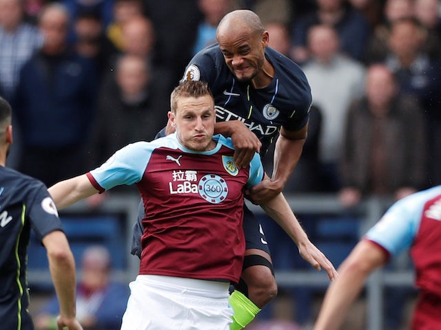 Vincent Kompany and Chris Wood in action during the Premier League game between Burnley and Manchester City on April 28, 2019