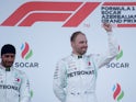 Valtteri Bottas celebrates winning the race on the podium as second placed Lewis Hamilton looks on on April 28, 2019